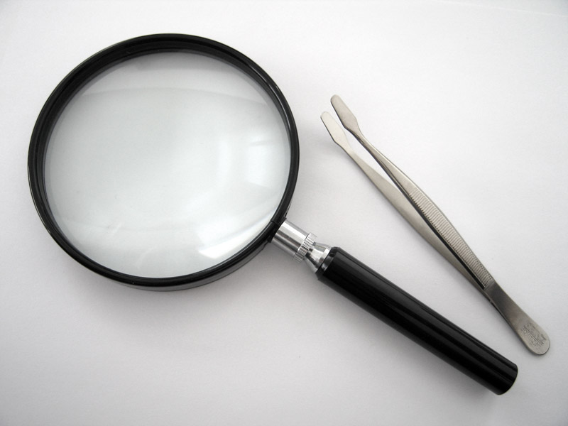 Magnifying glass and stamp tongs used for watermark detection